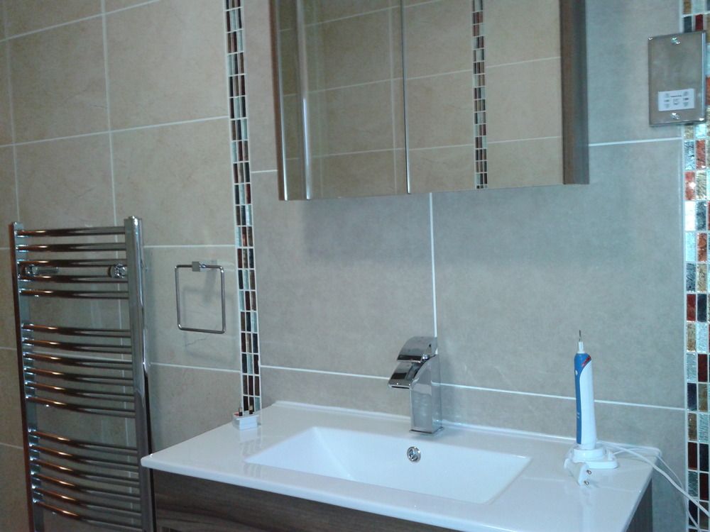 Chrome basin, mirror cabinet and feature tiling